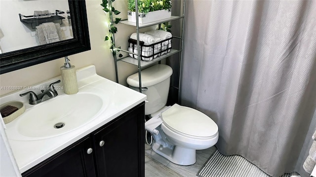 bathroom with hardwood / wood-style floors, vanity, and toilet