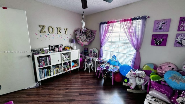 recreation room with dark hardwood / wood-style flooring, a textured ceiling, and ceiling fan