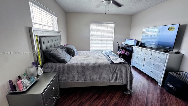 bedroom with ceiling fan, multiple windows, a textured ceiling, and dark hardwood / wood-style flooring