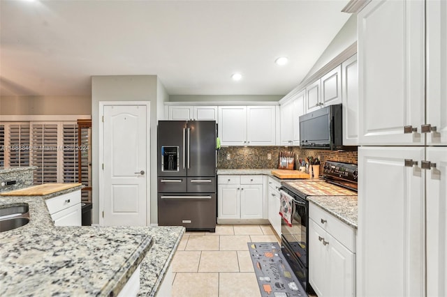 kitchen featuring white cabinetry, black appliances, light stone counters, light tile patterned floors, and decorative backsplash