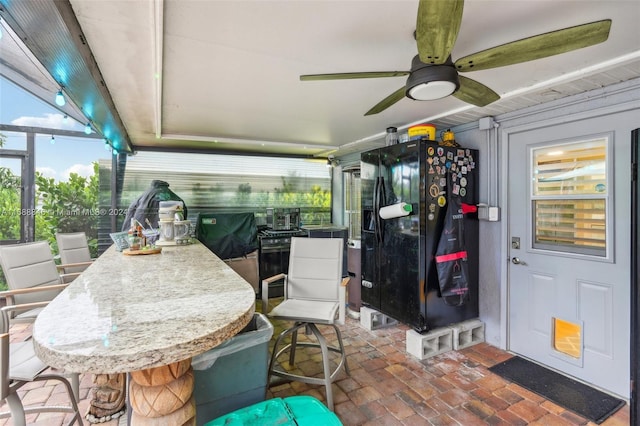 view of patio with glass enclosure and ceiling fan