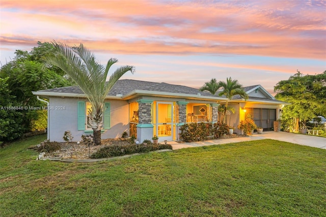 ranch-style home with a garage and a lawn