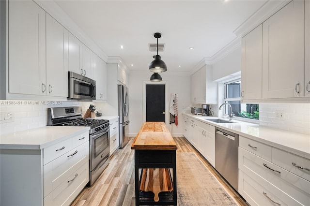 kitchen with light hardwood / wood-style floors, sink, white cabinetry, and stainless steel appliances