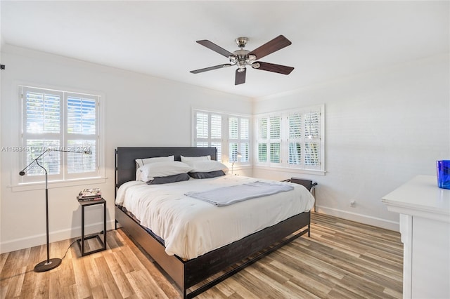 bedroom with hardwood / wood-style flooring, ceiling fan, and ornamental molding