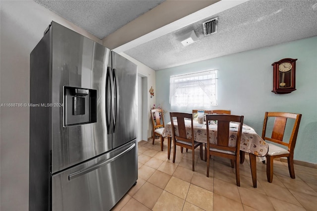 kitchen featuring stainless steel refrigerator with ice dispenser, a textured ceiling, and light tile patterned floors