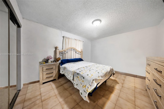 bedroom with a textured ceiling and light tile patterned flooring