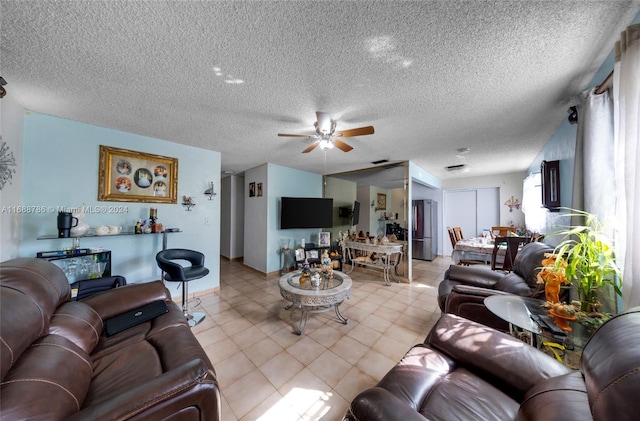 living room with ceiling fan and a textured ceiling