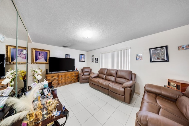 living room featuring a textured ceiling and light tile patterned floors