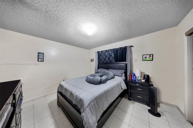 tiled bedroom featuring a textured ceiling