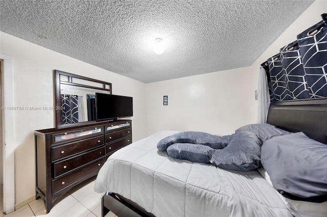 bedroom featuring a textured ceiling and light tile patterned flooring