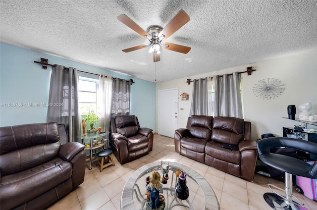 living room featuring a textured ceiling, light tile patterned floors, and ceiling fan