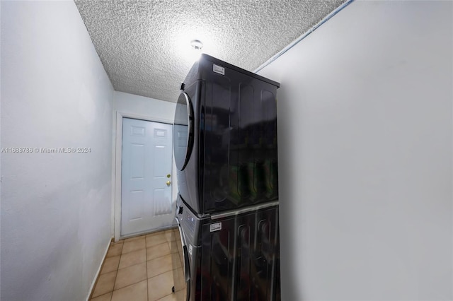 washroom with stacked washer and clothes dryer, a textured ceiling, and light tile patterned floors