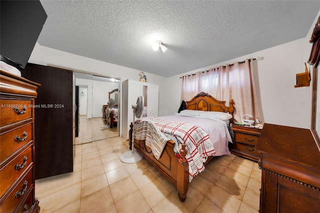 bedroom with a textured ceiling and light tile patterned flooring