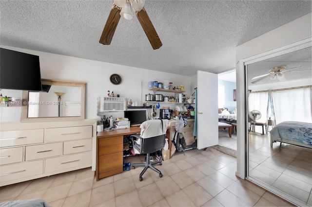 tiled office space featuring ceiling fan and a textured ceiling