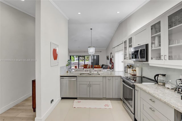 kitchen with light hardwood / wood-style floors, lofted ceiling, light stone counters, sink, and appliances with stainless steel finishes