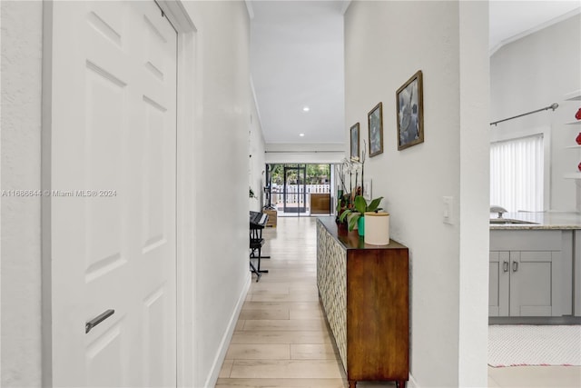 hallway with sink and light hardwood / wood-style flooring