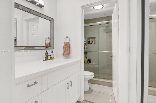 bathroom featuring vanity, tile patterned floors, an enclosed shower, and toilet