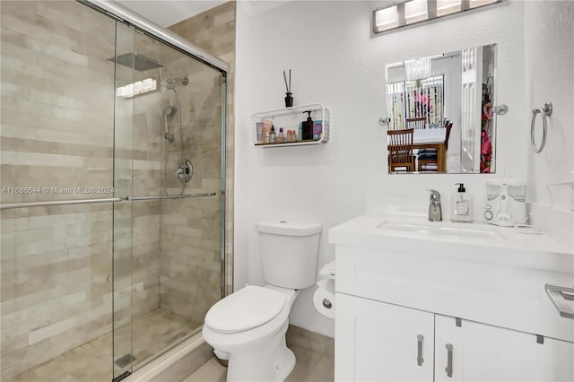 bathroom featuring an enclosed shower, vanity, and toilet