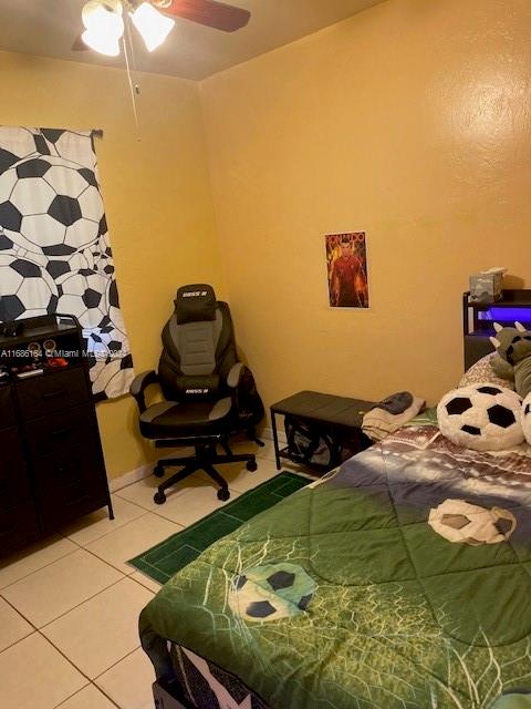 tiled bedroom featuring ceiling fan