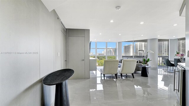 spare room featuring a wall of windows and light tile patterned floors