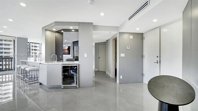 kitchen with wall chimney exhaust hood, sink, gray cabinets, backsplash, and appliances with stainless steel finishes