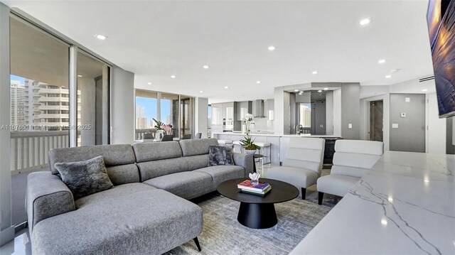 kitchen featuring light tile patterned flooring, sink, light stone countertops, expansive windows, and dishwasher