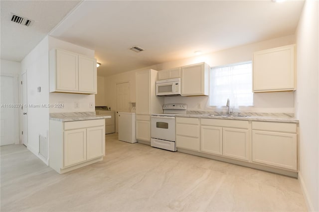 kitchen with washer and clothes dryer, white appliances, and sink