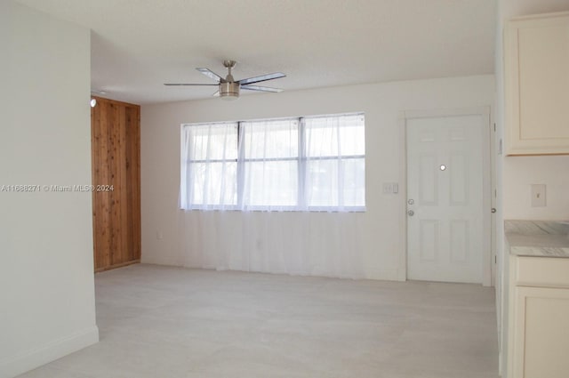 spare room featuring ceiling fan and wooden walls