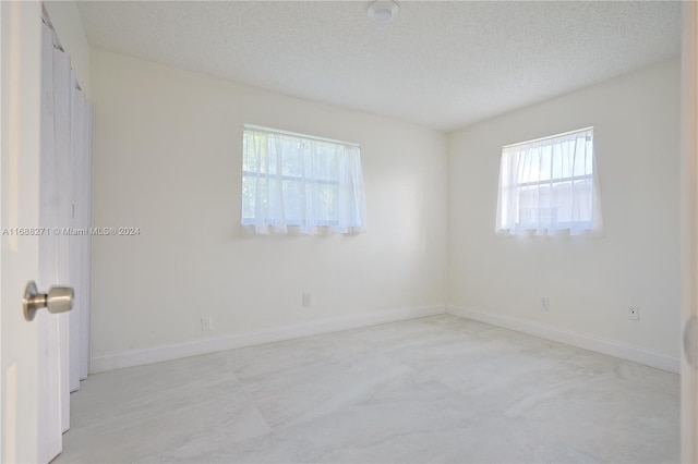 unfurnished room featuring a textured ceiling