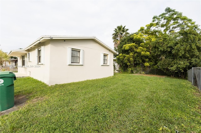 view of side of home with a yard