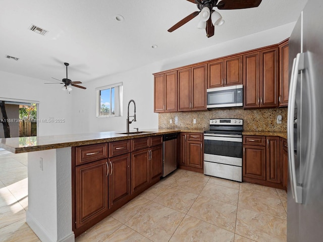 kitchen with stone countertops, tasteful backsplash, sink, kitchen peninsula, and stainless steel appliances