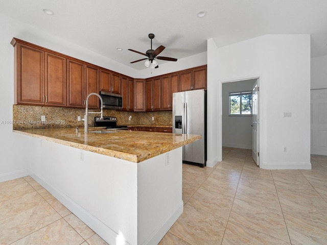 kitchen featuring light stone counters, kitchen peninsula, ceiling fan, stainless steel appliances, and backsplash