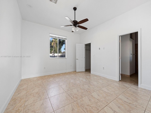 unfurnished bedroom featuring a spacious closet and ceiling fan