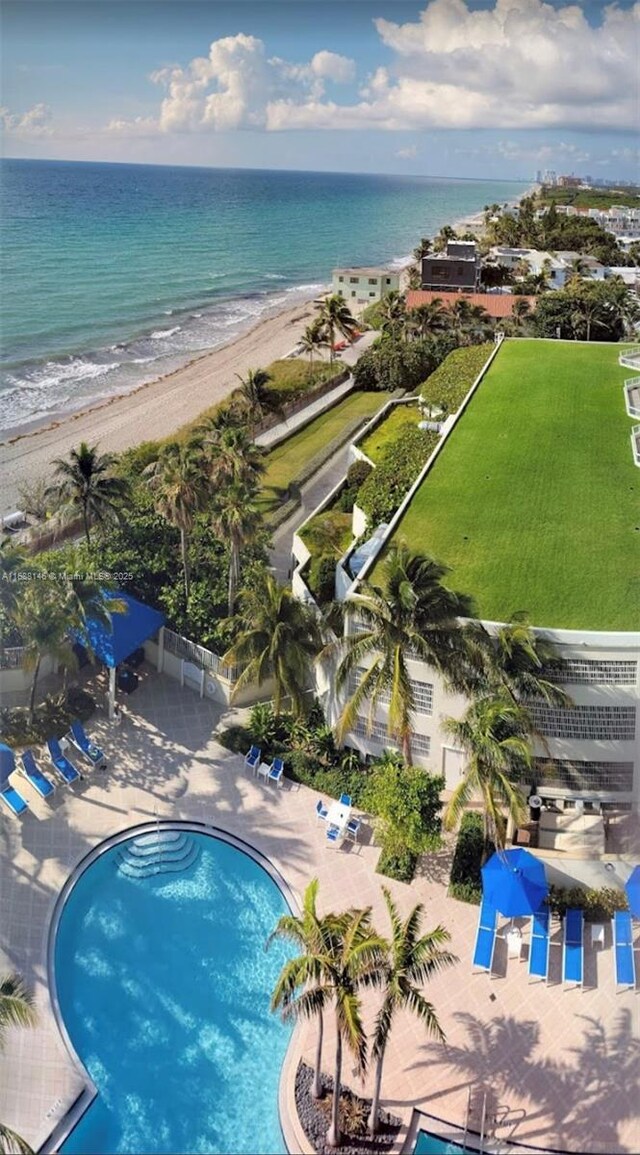 birds eye view of property featuring a water view and a beach view