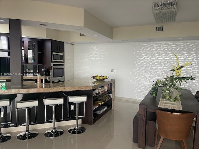 kitchen featuring stainless steel appliances, a kitchen bar, and kitchen peninsula