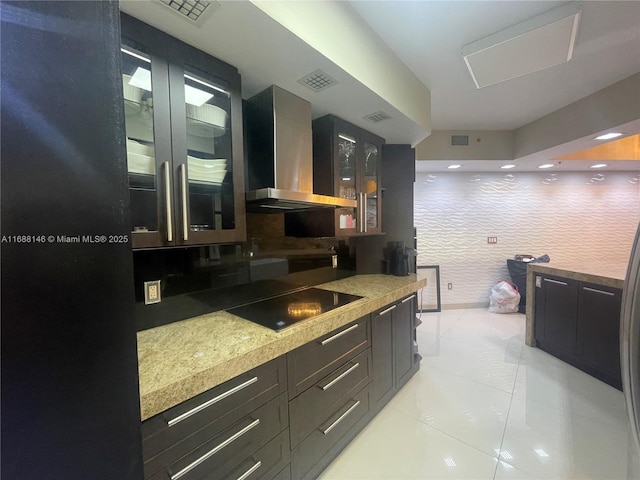 kitchen with black electric cooktop, decorative backsplash, and wall chimney range hood