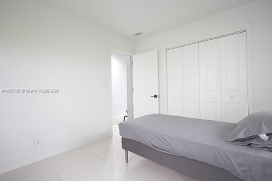 bedroom with light tile patterned floors and a closet