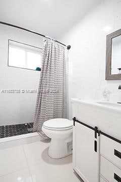 bathroom with a shower with curtain, tile patterned flooring, vanity, and toilet