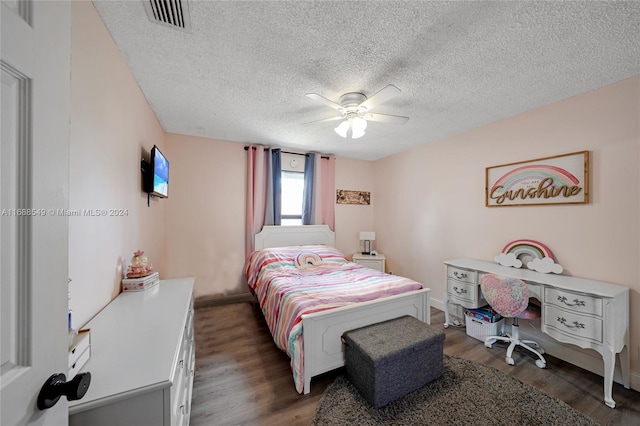 bedroom with ceiling fan, a textured ceiling, and dark hardwood / wood-style flooring