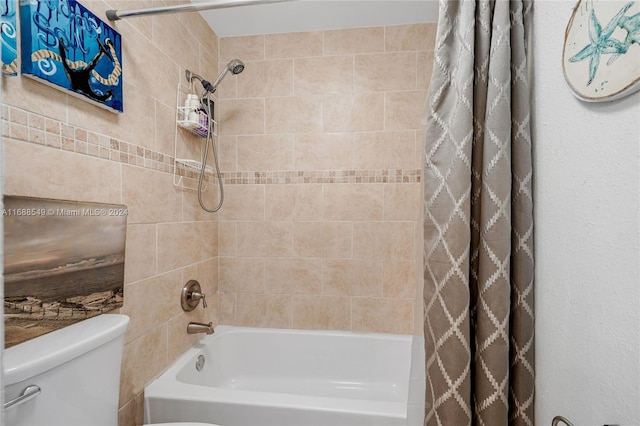 bathroom featuring toilet and shower / bath combination with curtain