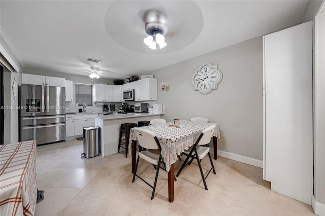 tiled dining space featuring ceiling fan