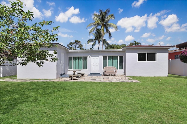 back of property featuring a patio and a lawn