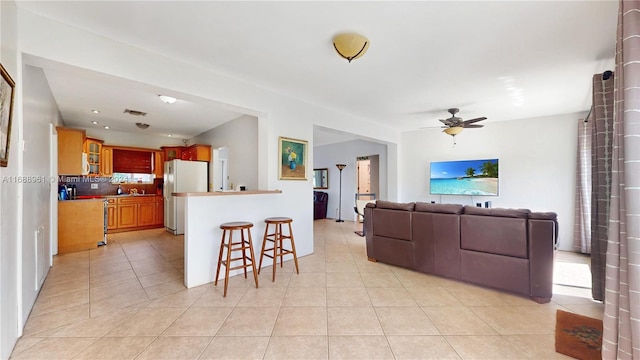 tiled living room with ceiling fan