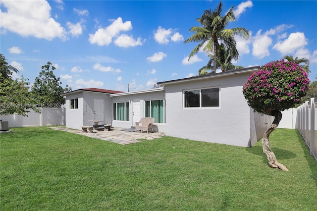 back of house featuring cooling unit, a patio area, and a yard