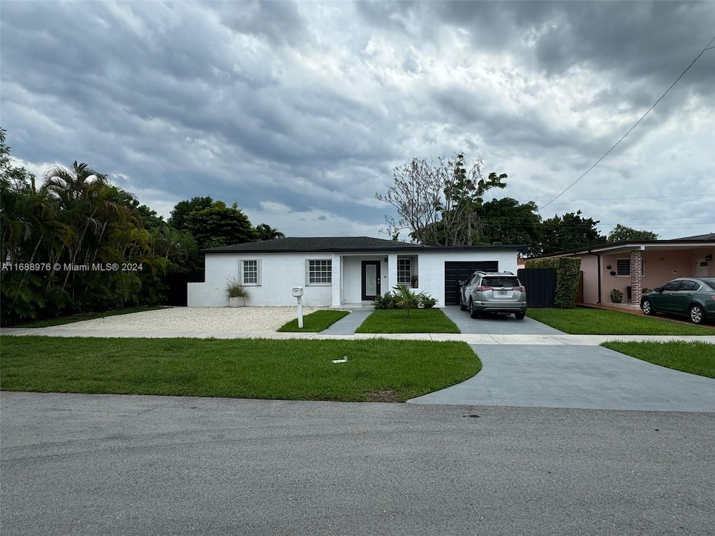 ranch-style house featuring a front yard and a garage