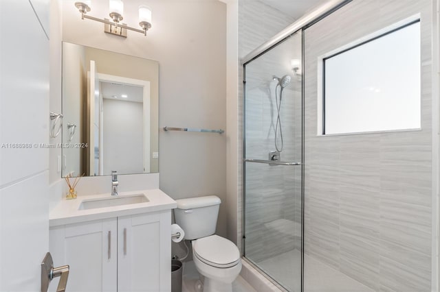 bathroom with a shower with shower door, vanity, and toilet