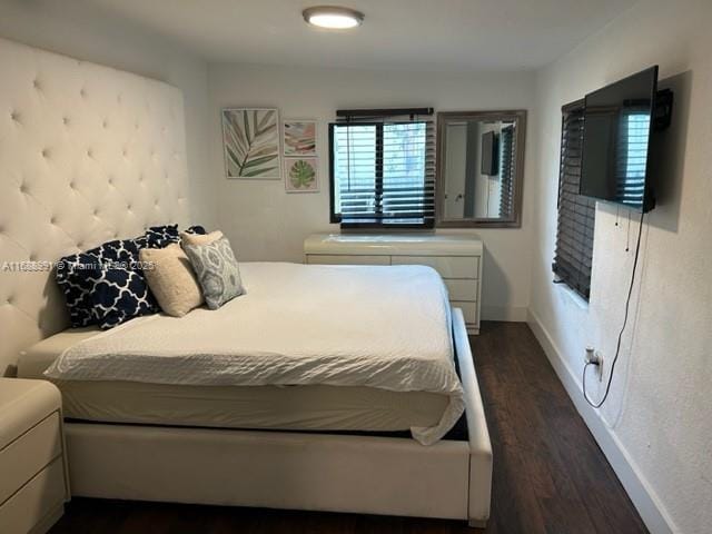 bedroom featuring dark wood finished floors and baseboards