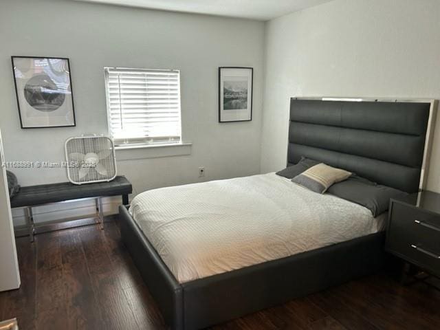 bedroom with dark hardwood / wood-style floors