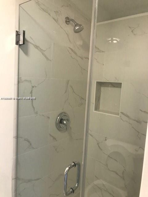 bathroom with a shower with door