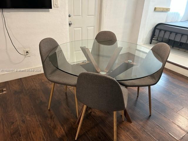 dining area featuring dark wood-style floors and baseboards